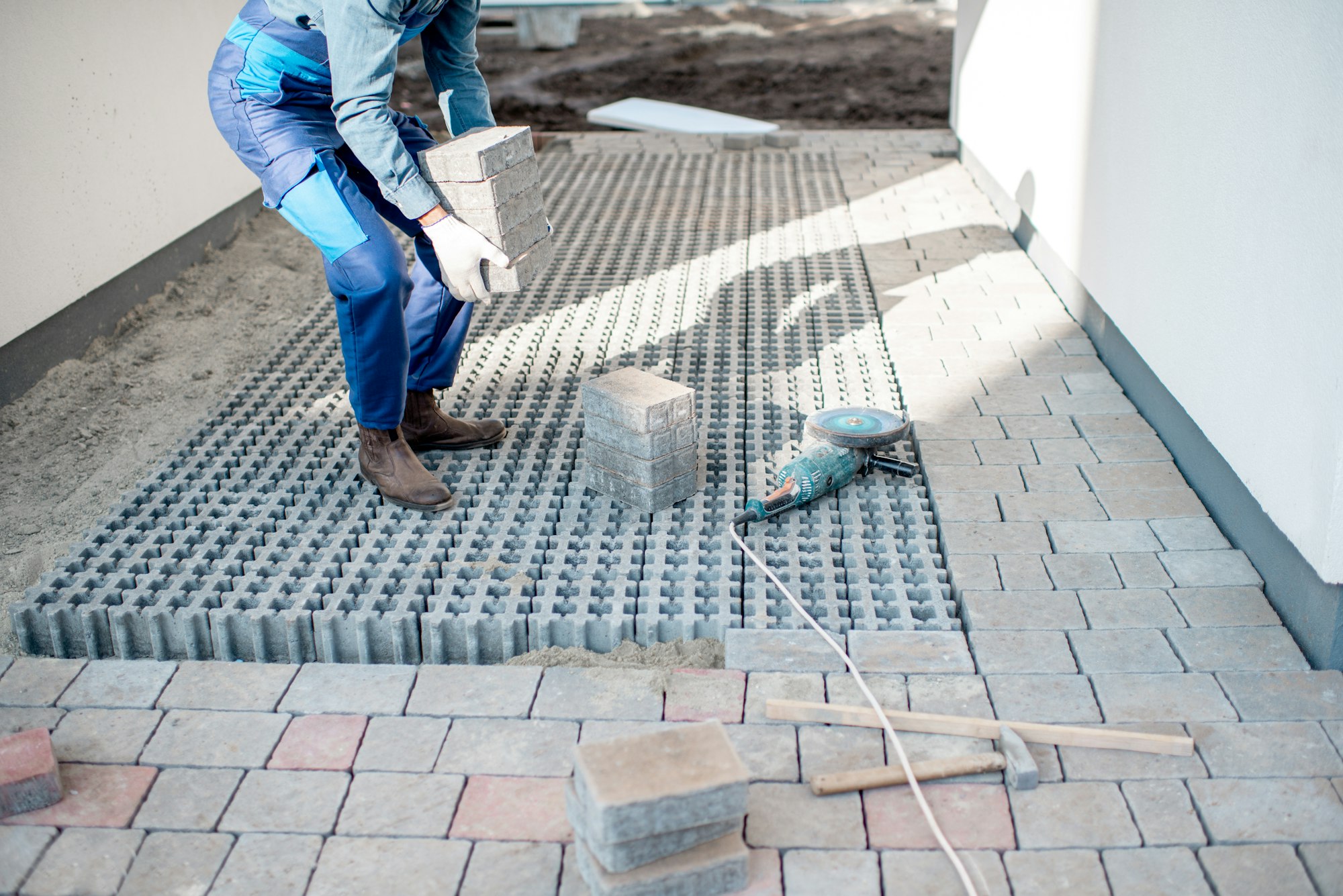 Builder laying paving tiles