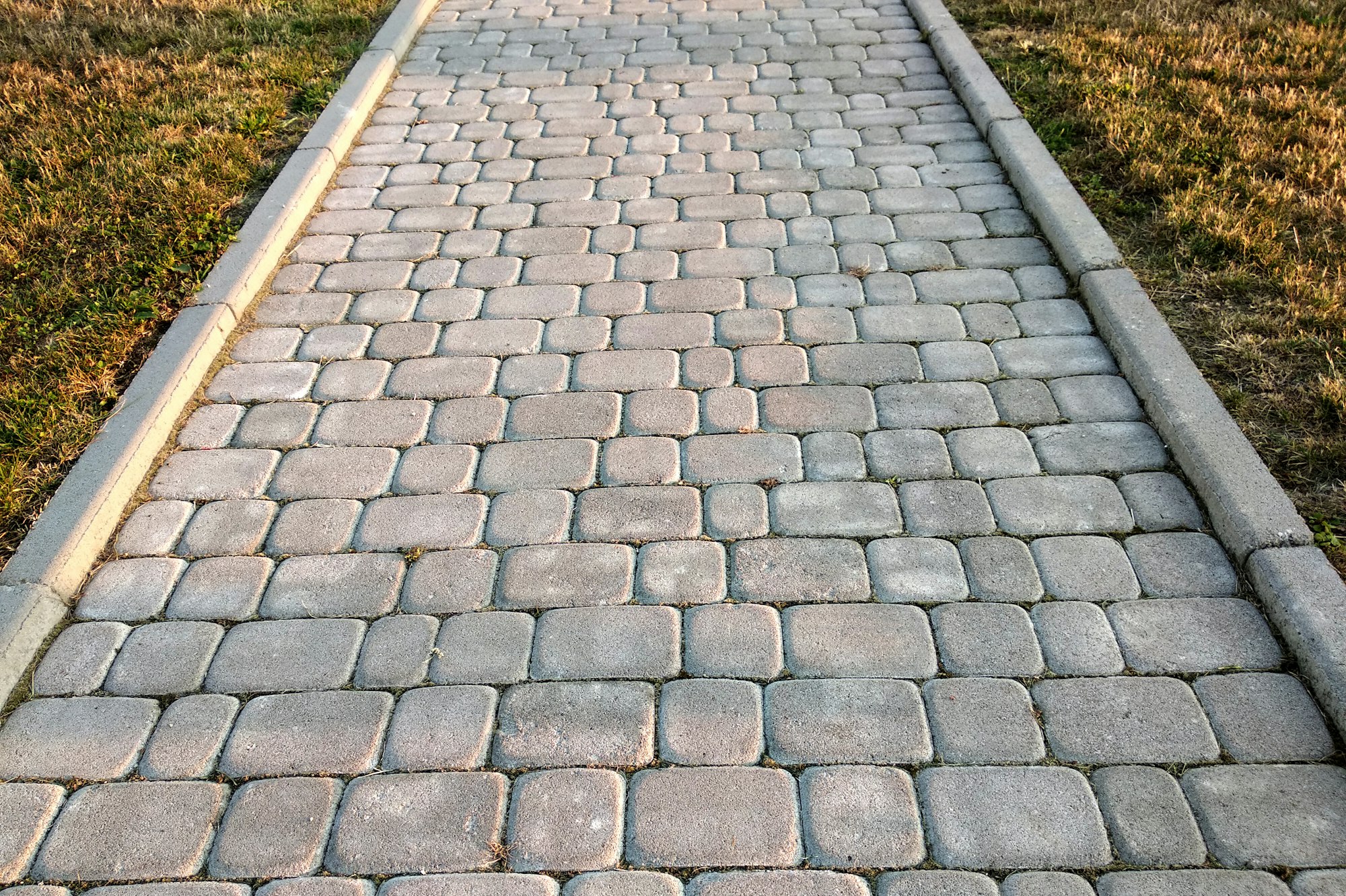 Close-up of slab stone paved path way at park or backyard. Walkway footpath road at house yard