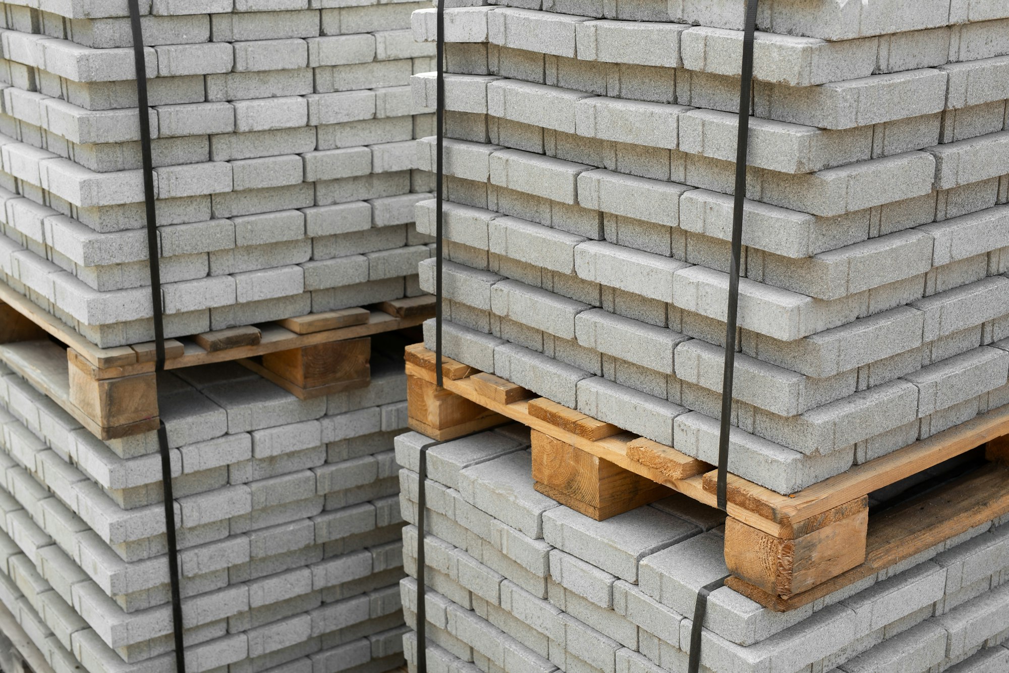 Stack of contemporary stone Paving slabs pavers. Building material on pallet for road paving.